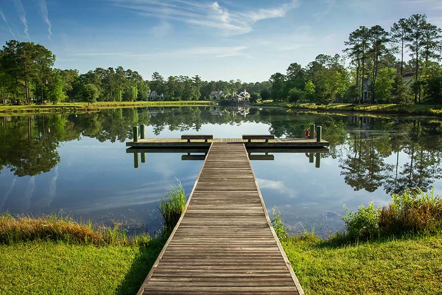 Moncks Corner, SC - Landscape View of a Pier Over a Still Lake with Blue Skies in Moncks Corner, South Carolina